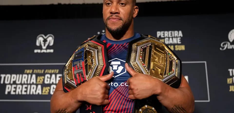 Fighter holding two championship belts at event