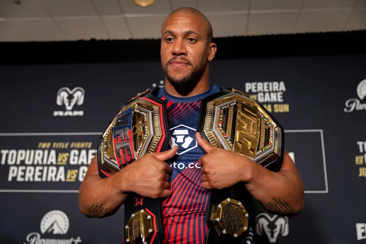 Fighter holding two championship belts at event