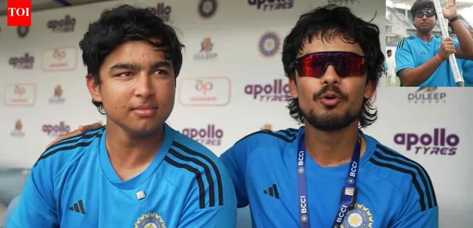Two young cricketers in blue jerseys at press conference