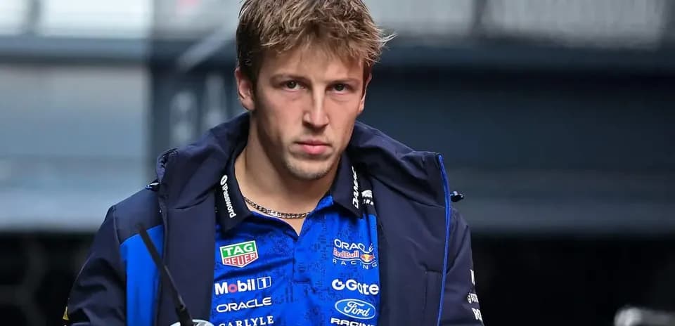 Driver in team jacket holding a drink bottle