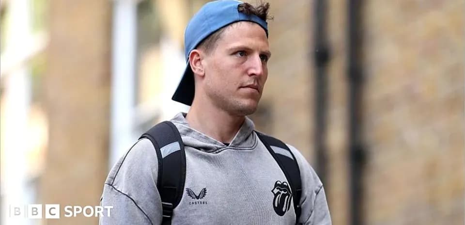 Person wearing a hoodie and cap walking outdoors