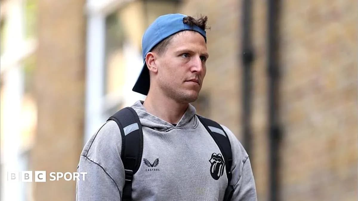 Person wearing a hoodie and cap walking outdoors