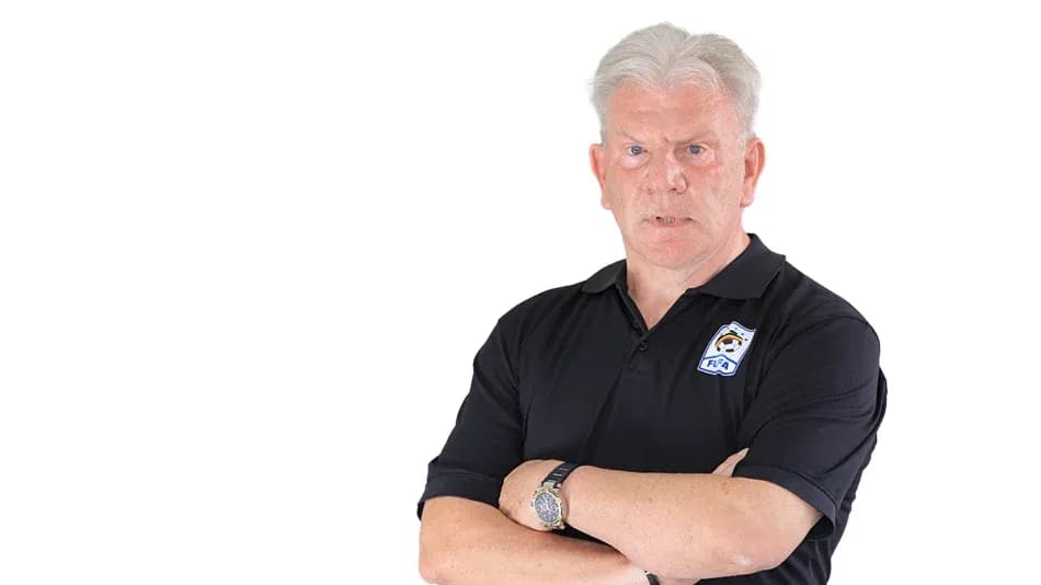 Coach with arms crossed, wearing a black polo shirt