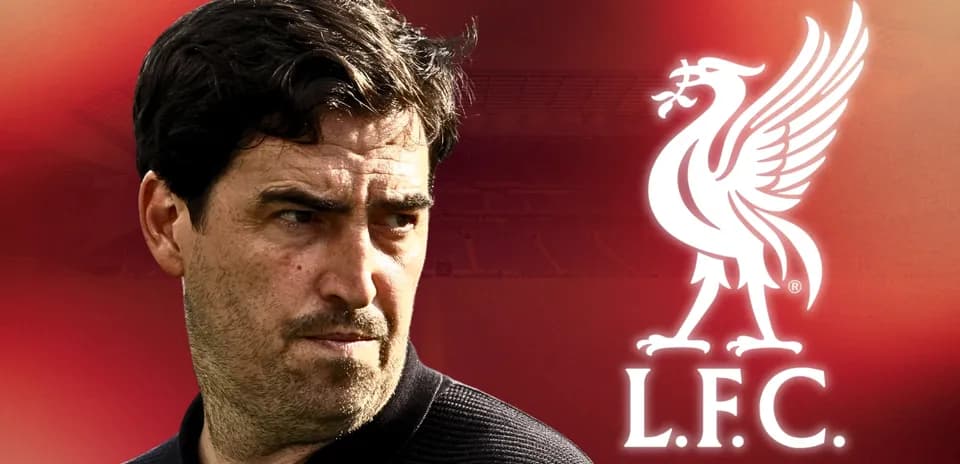 Coach in front of Liverpool FC logo and stadium