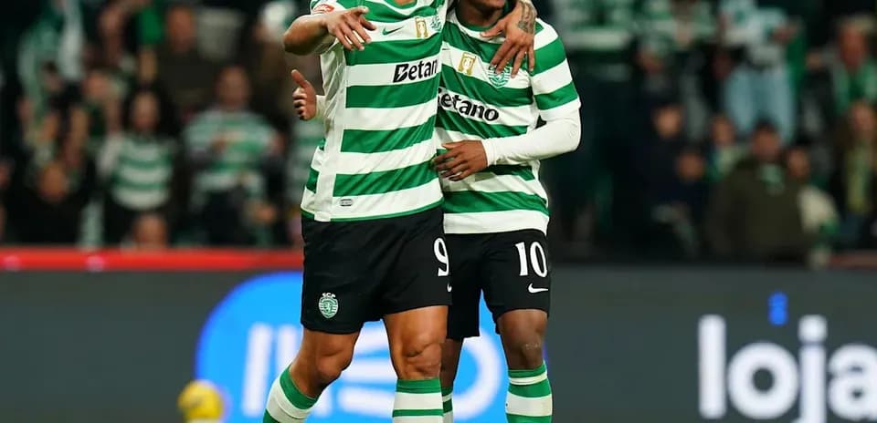 Two players celebrating on the pitch in striped jerseys
