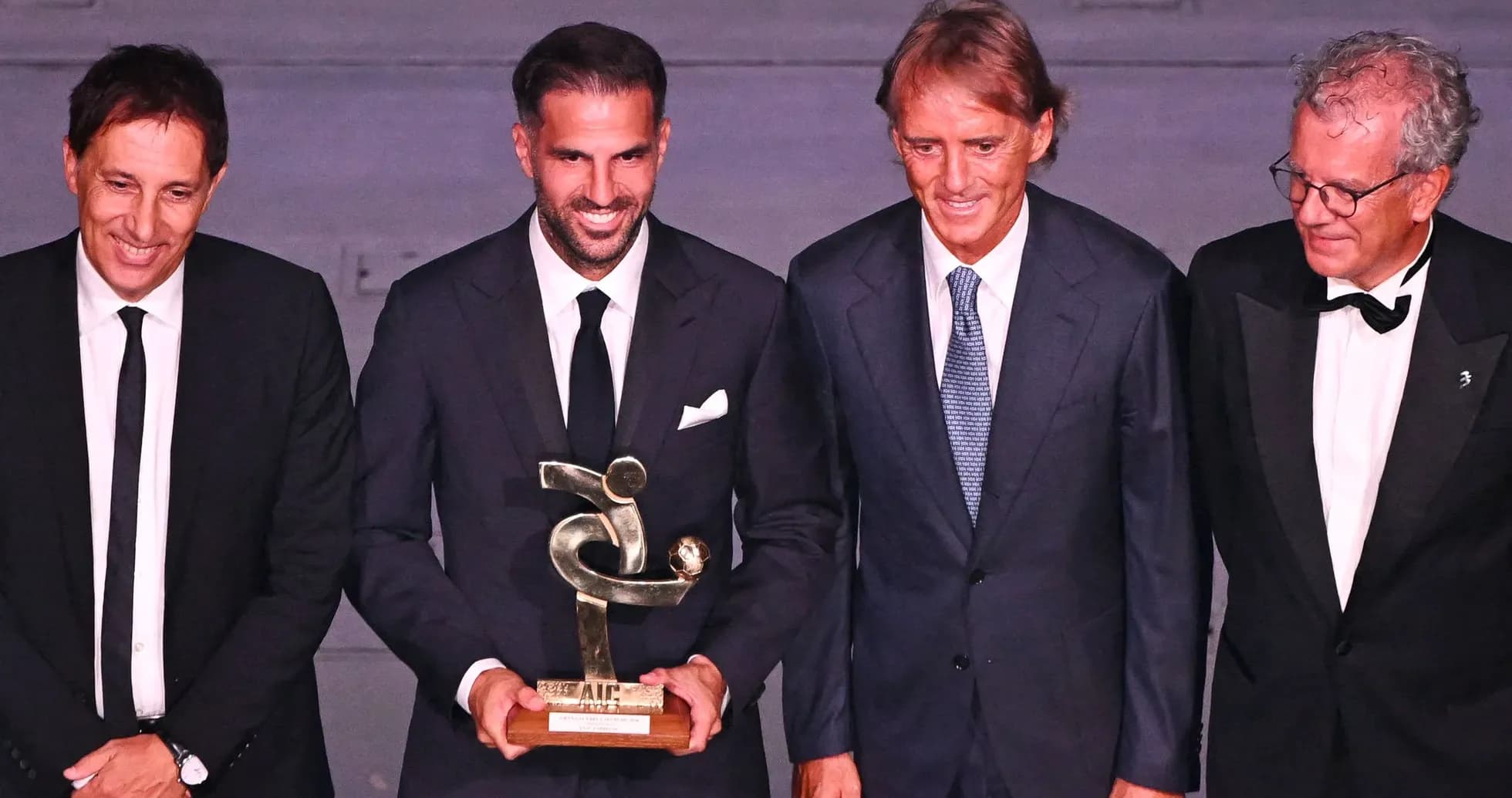 Four men posing with an award at an event