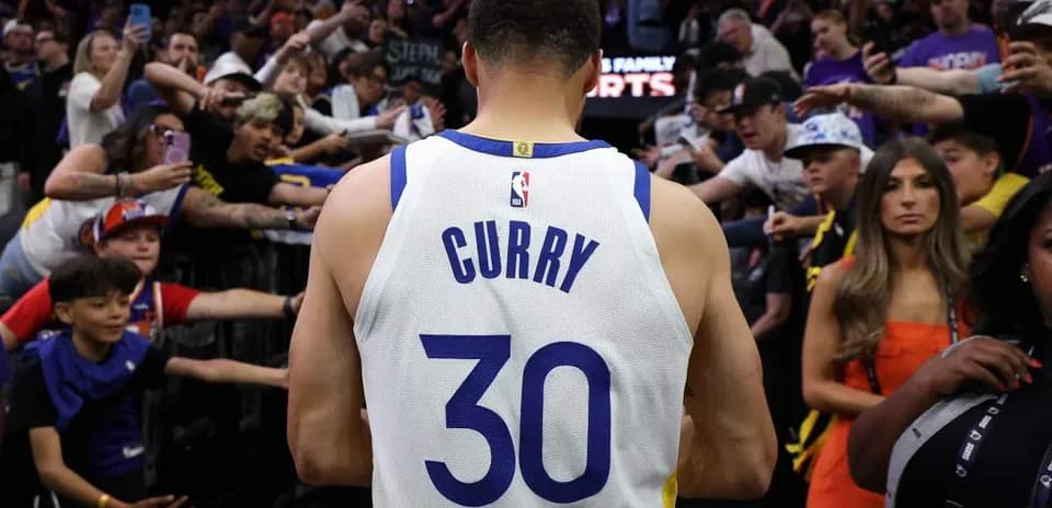 Player in jersey walking past enthusiastic fans