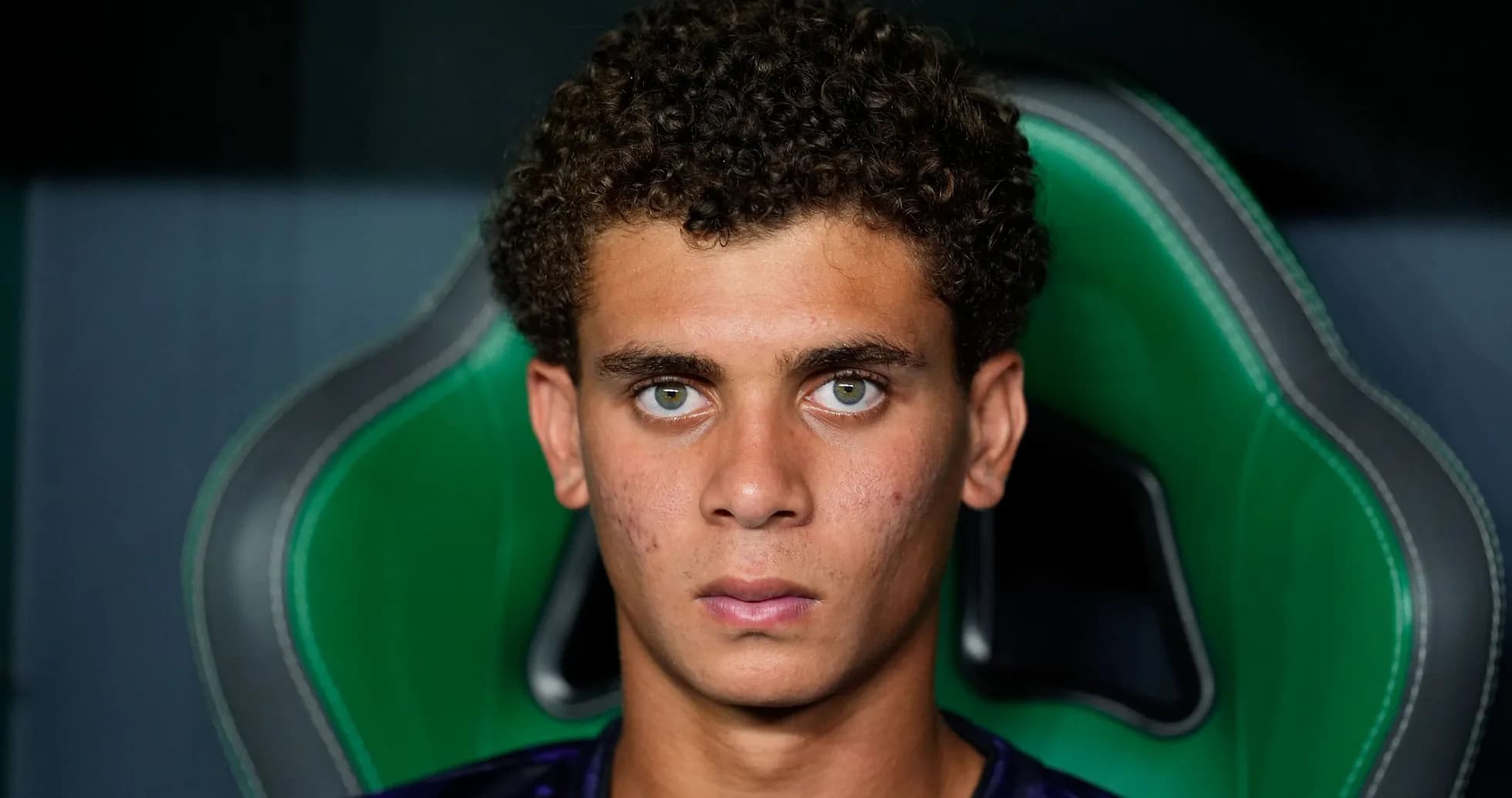 Young athlete sitting in a sports chair, looking serious