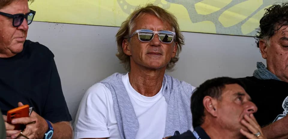 Man with sunglasses sitting in spectator area