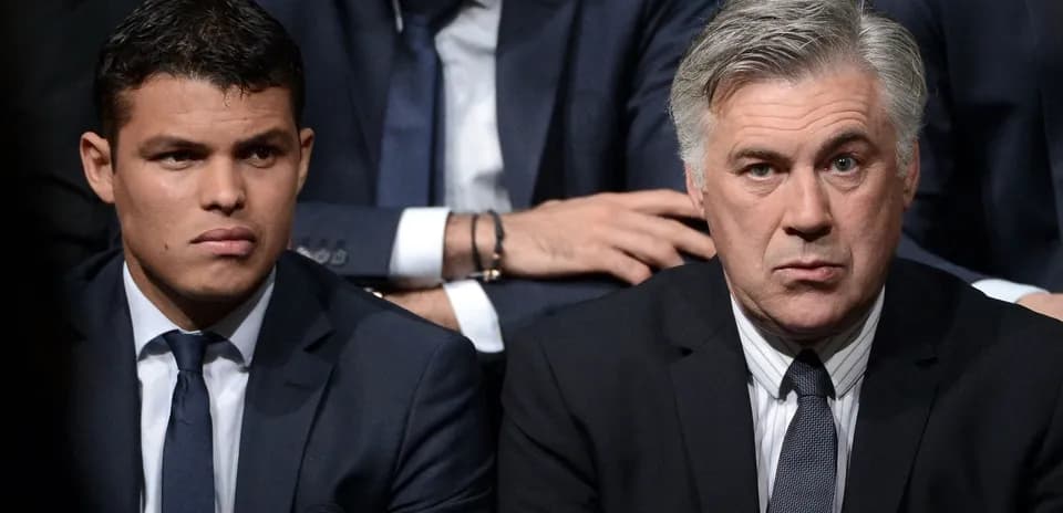 Two men in suits sitting together at event
