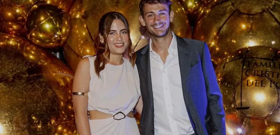 Man and woman posing in front of golden decorations