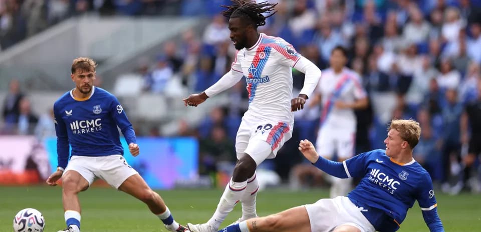 Player in white dribbling past two defenders in blue