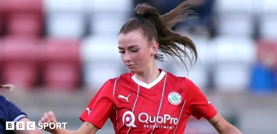 Player in red jersey dribbling the ball on field