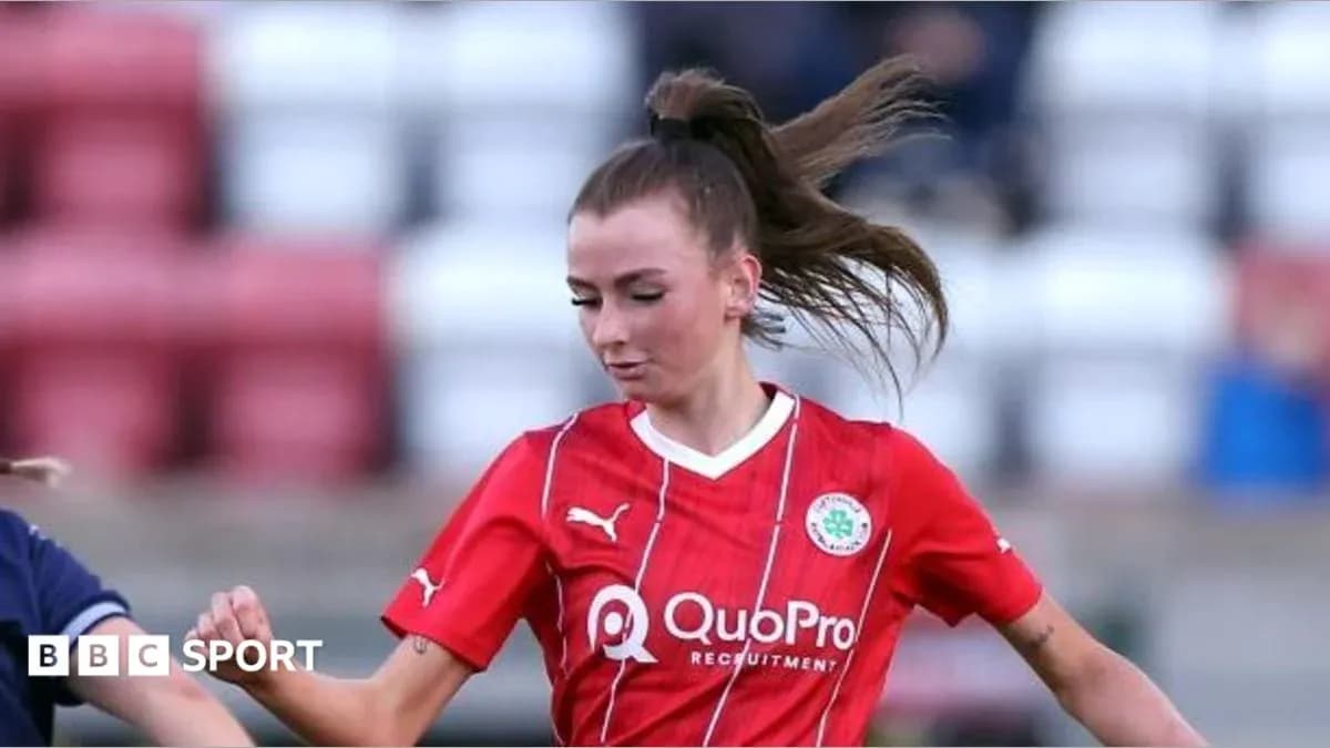 Player in red jersey dribbling the ball on field