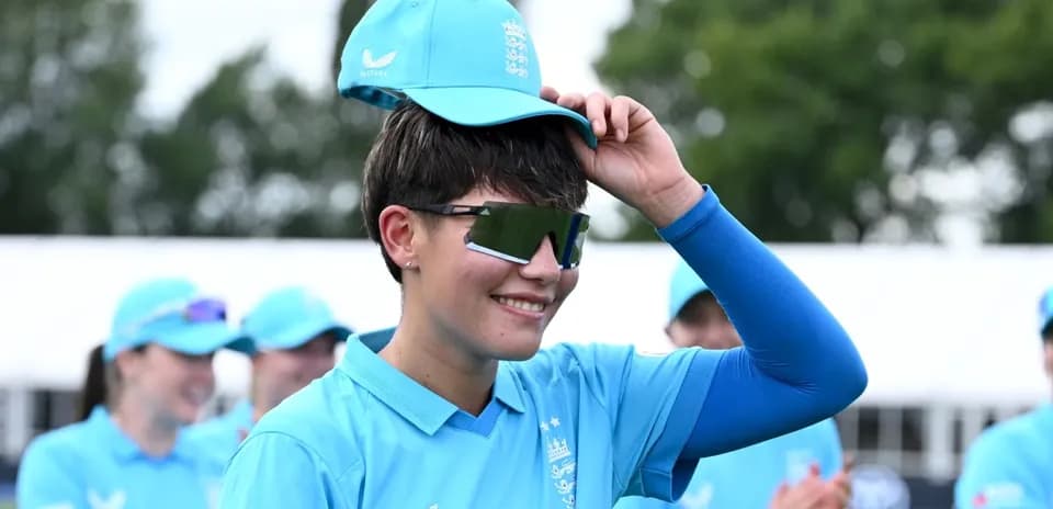 Player adjusting cap during team event in blue uniform