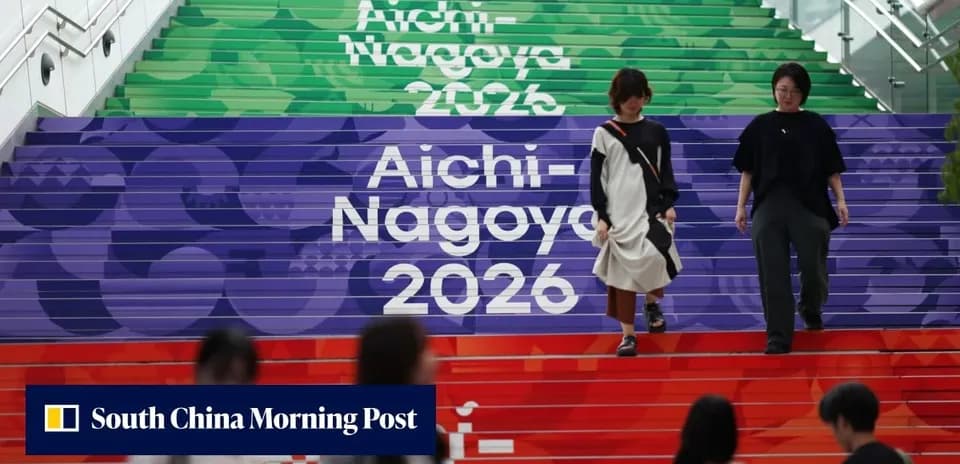 Two women walking down colorful steps labeled Aichi-Nagoya 2026