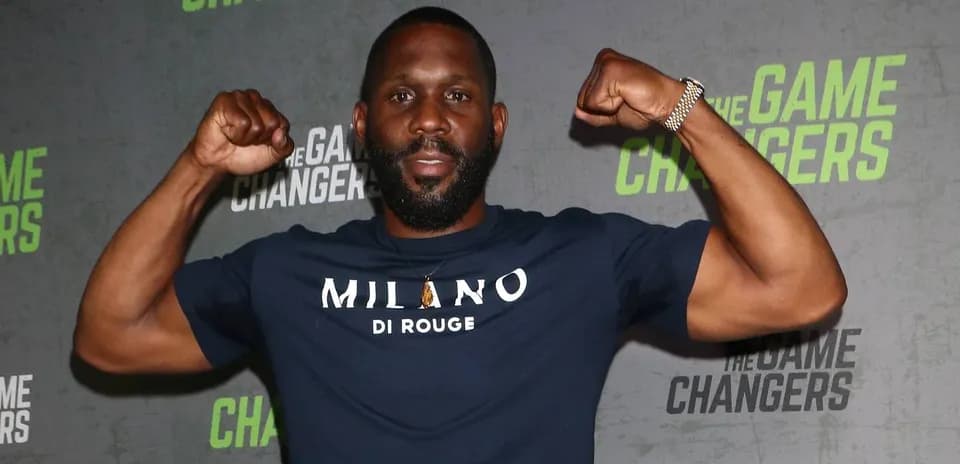 Man flexing muscles at event backdrop