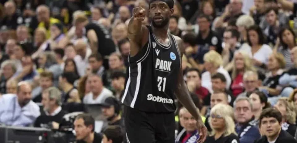 Player signaling during basketball game with crowd behind