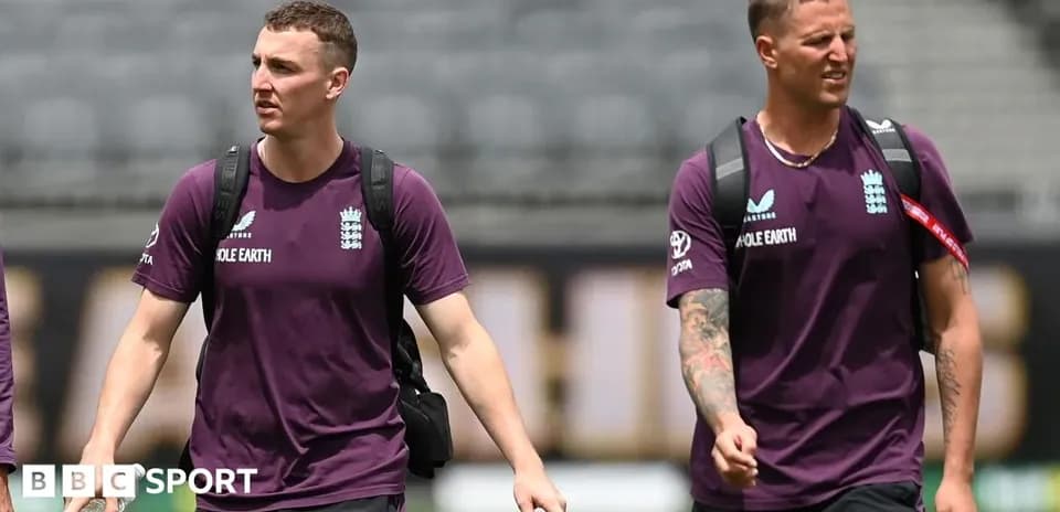 Two England cricketers walking onto the field