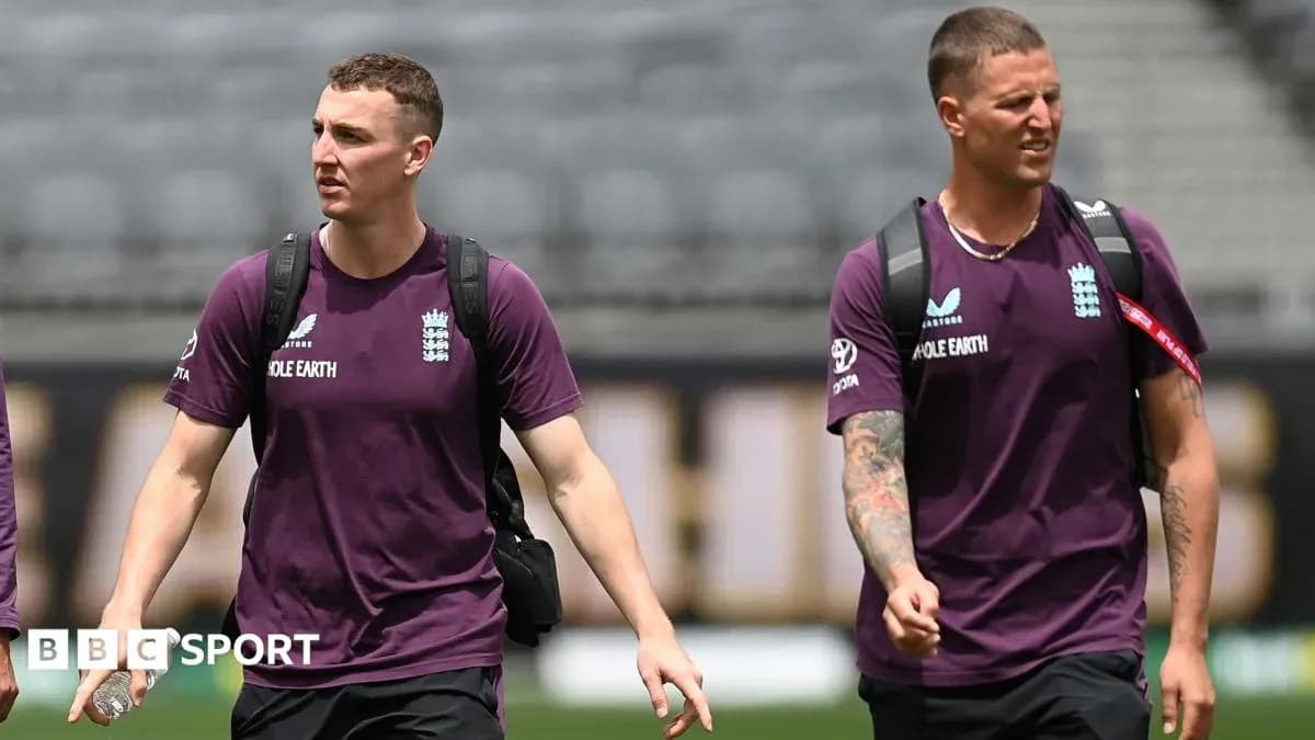 Two England cricketers walking onto the field