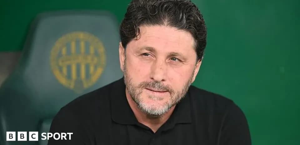 Manager seated on bench during match preparation