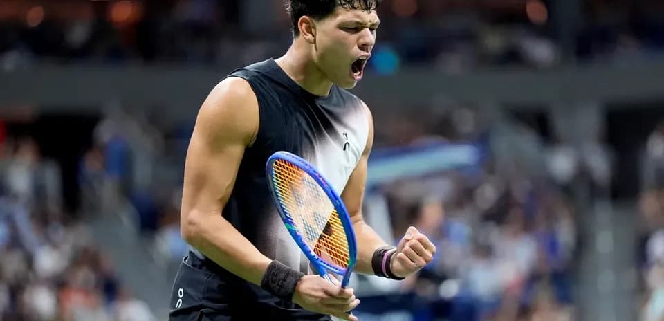 Tennis player celebrating with racket after winning point