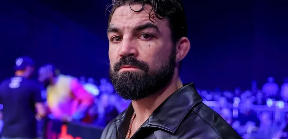 Man with beard in black jacket at event