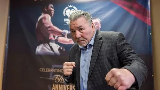 Man posing in boxing stance near promotional banner