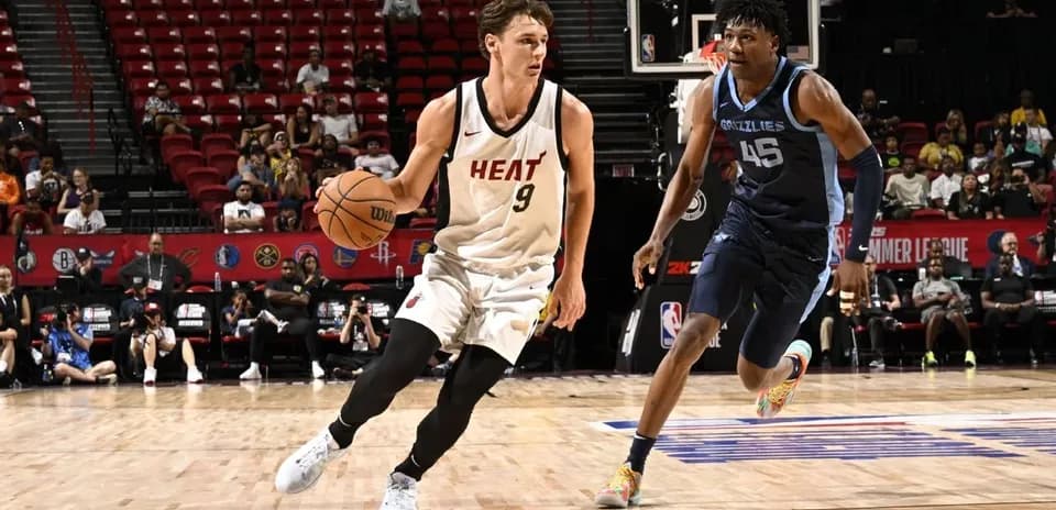 Player from Miami Heat dribbling past Memphis Grizzlies defender