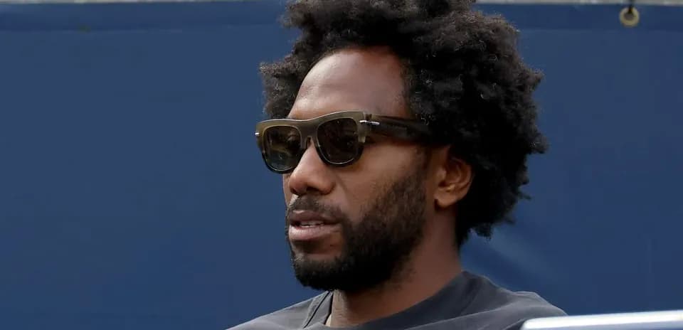 Man with sunglasses sitting in the stands