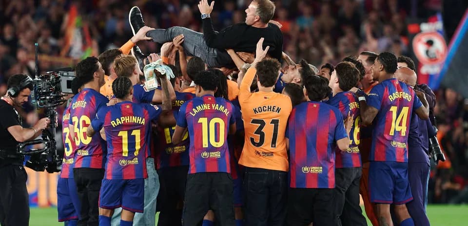 Barcelona players celebrating and lifting their coach