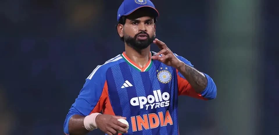 Cricketer gesturing while holding a ball on field