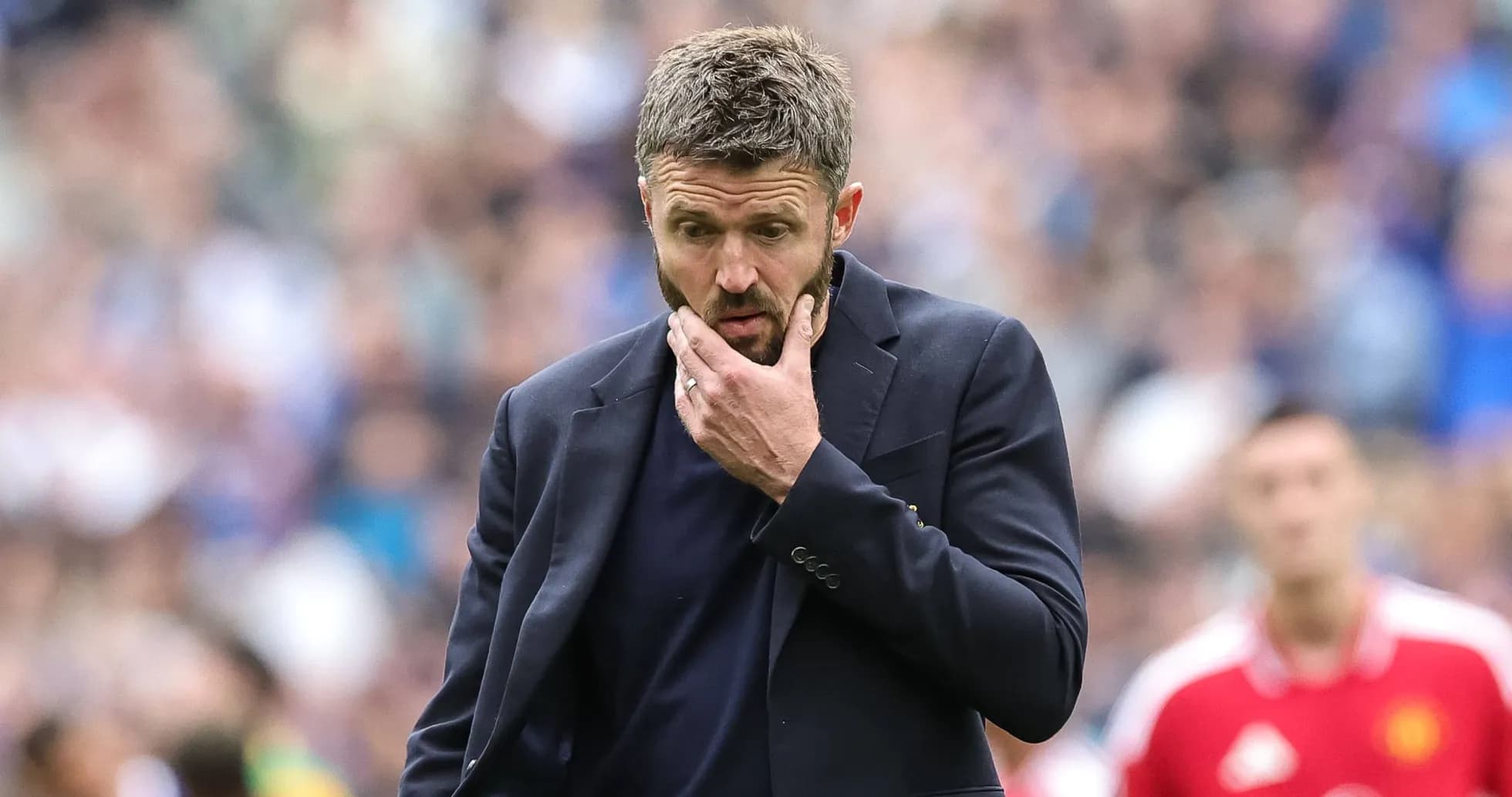 Coach pondering during a match on the sidelines