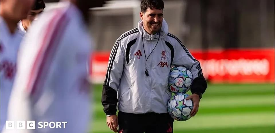 Liverpool coach holding footballs during training session