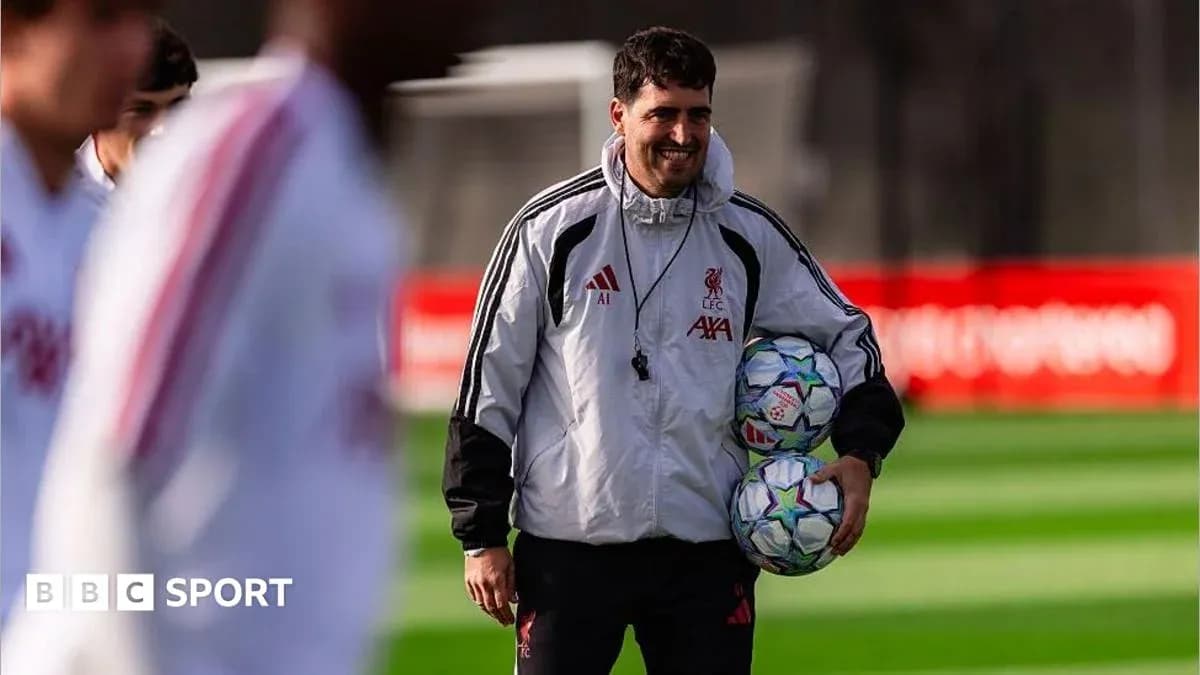 Liverpool coach holding footballs during training session