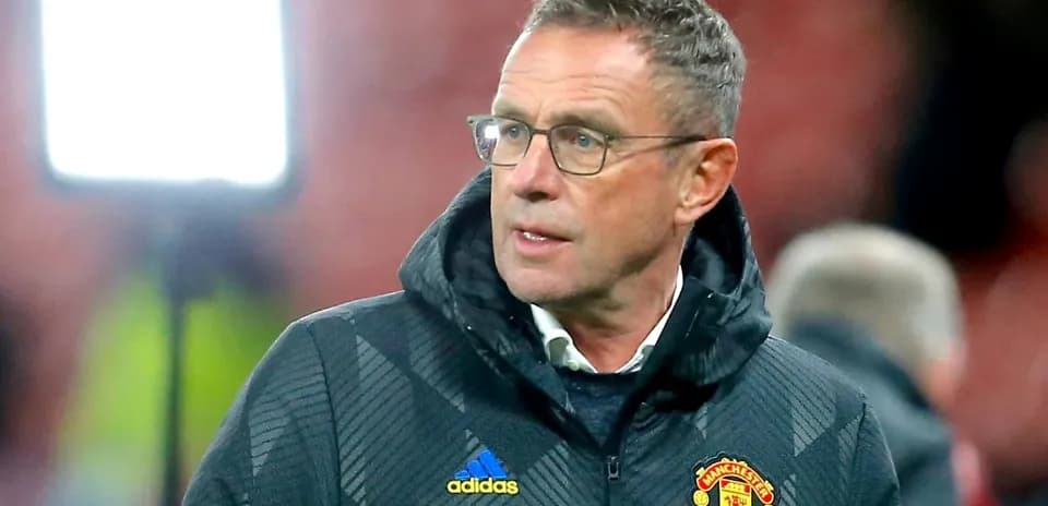 Coach wearing Manchester United jacket during match