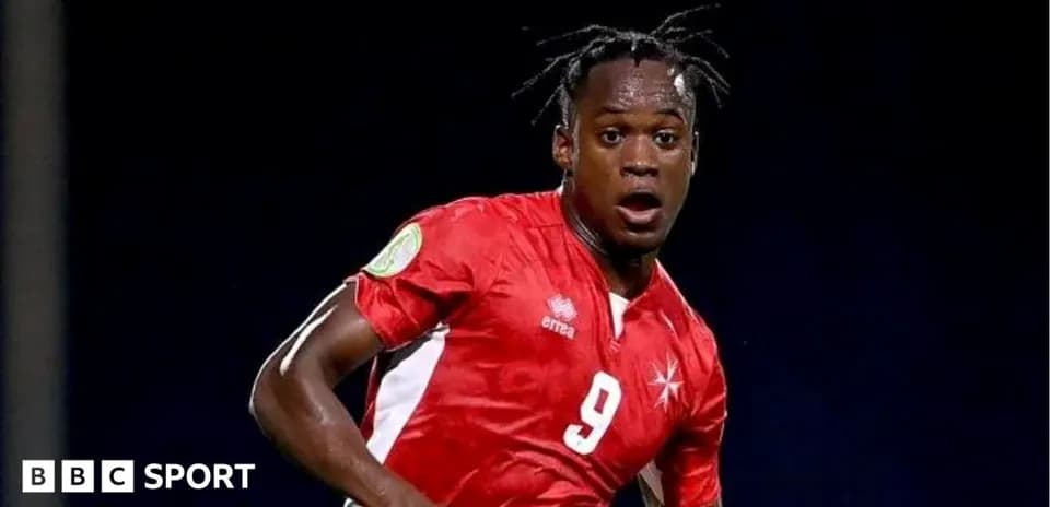 Player in red jersey during football match action