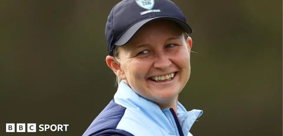 Smiling woman wearing cricket cap and jacket