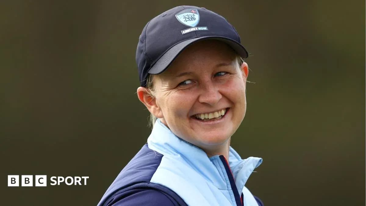 Smiling woman wearing cricket cap and jacket