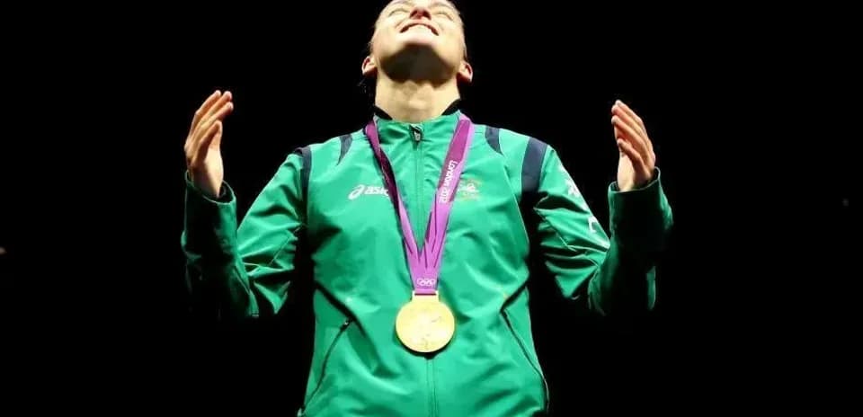 Athlete celebrating with gold medal in dark setting