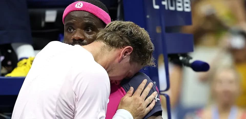 Two tennis players embracing during a match