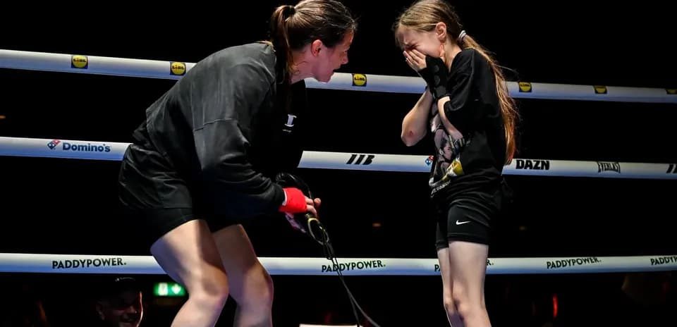 Boxer interacting with young girl in ring
