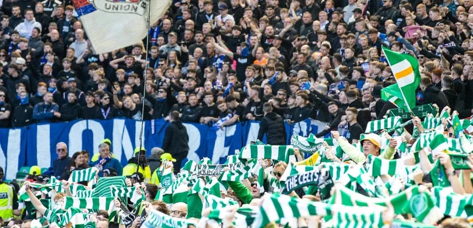 Fans waving scarves in a packed stadium