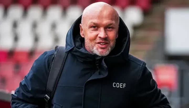 Man in a black jacket walking into stadium