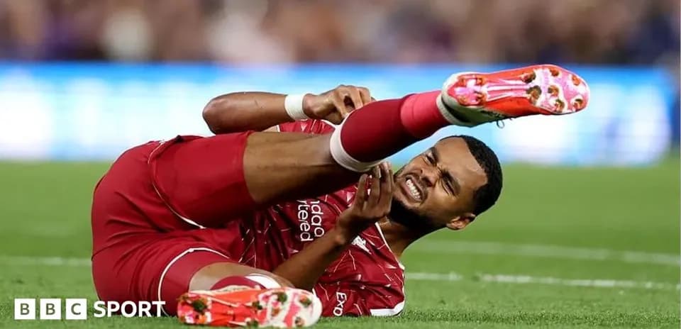 Player in red jersey lying injured on the field