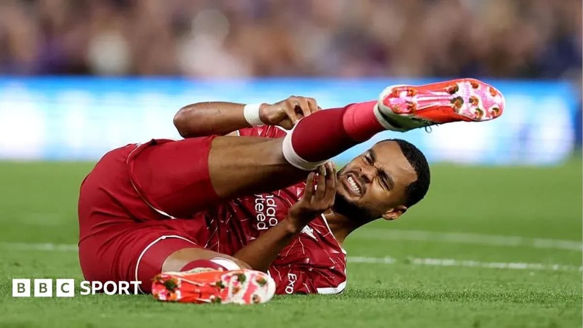 Player in red jersey lying injured on the field