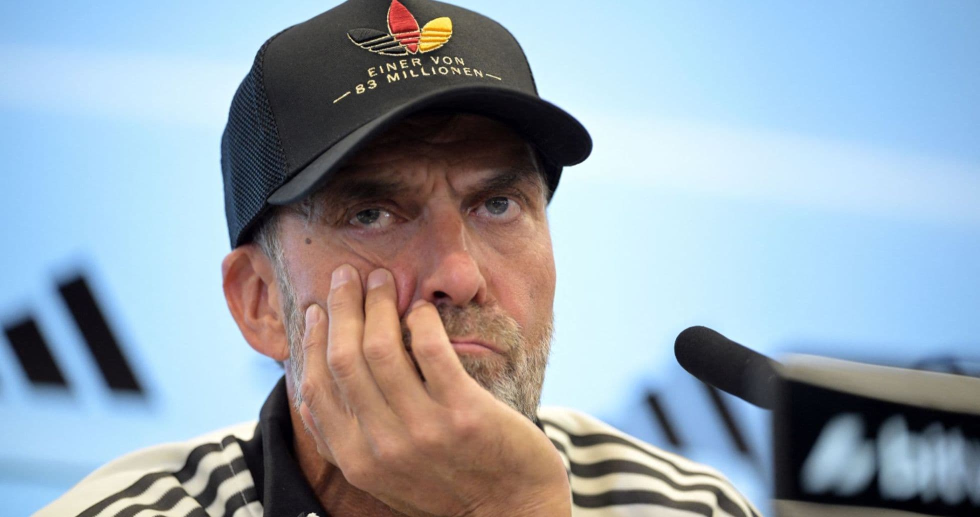 Manager at press conference with hand on face