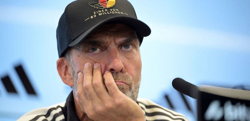 Manager at press conference with hand on face