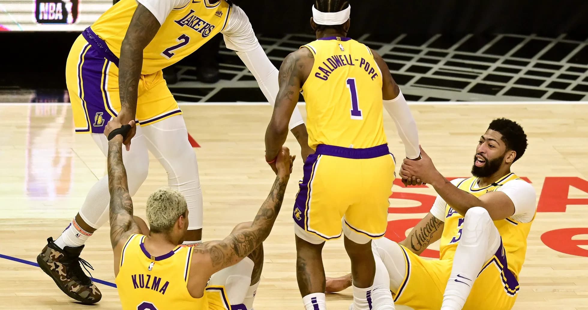 Lakers players helping teammates on the court