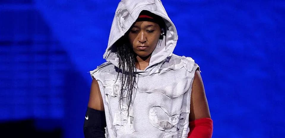 Athlete wearing a hooded, torn outfit on stage